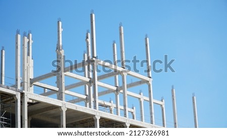 bearing pillars of the building. Structure building of steel structure roof truss frame installation by mobile crane under the construction building in the factory with blue sky