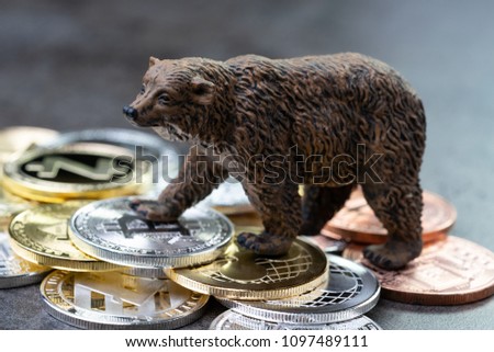 Bearish market concept, price down or falling demand collapse of crypto currency, bear figure standing on various of cryptocurrency physical coins, Bitcoin, Ripple, ZCash, Litecoins, Ethereum.