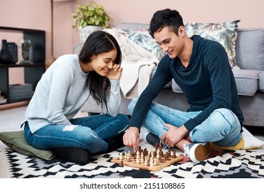 Beat The Lockdown Blues With A Fun Board Game. Shot Of A Young Couple Playing A Game Of Chess At Home.