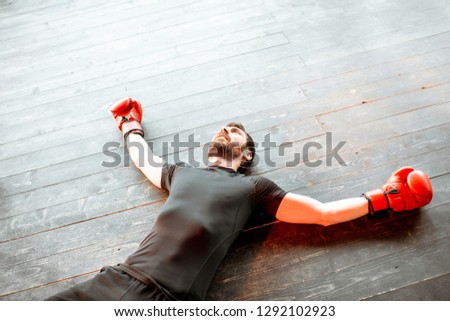 Beaten man lying on the floor of the boxing ring during the knockout