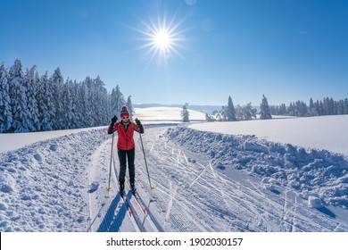 beatiful active senior woman cross-country skiing in fresh fallen powder snow in the Allgau alps near Immenstadt, Bavaria, Germany