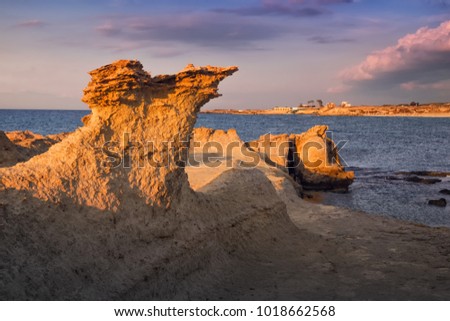 Beatiful Cyprus sunset on the desert empty rocky coast with strange fiqures at the Halk beach