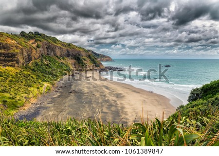 Beatiful empty black sand beach at Maori bay near Muriwai beach, North Island, New Zealand
