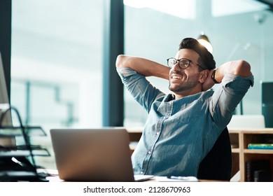 Beating the deadline like the champ he is. Shot of a young businessman taking a break at his desk in a modern office. - Powered by Shutterstock