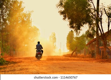 Beating the dust... A motorist passing through the dust created by an industrial truck (which is of course hidden behind the dust in this photo)... somewhere in Bangalore city outskirts....