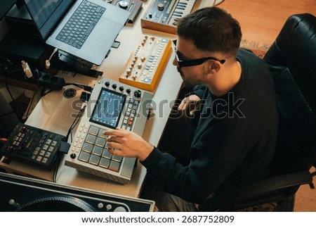 Beatmaker in a studio producing some music with an Akai MPC LIVE II