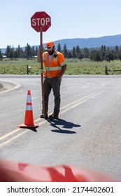 Beatty, OregonUSA - June 22, 2022: Flagger Holding Up A Temporary Stop Sign For Road Construction On Highway 140