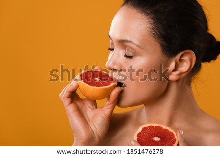 Beaty portrait of a young woman on a yellow background. The woman tastes like grapefruit.