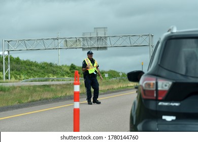 Beausejour Marsh, Nova Scotia / Canada - July 12 2020:  Officer Checking And Directing Vehicles On The New Brunswick Nova Scotia Border During Covid 19  Virus Pandemic