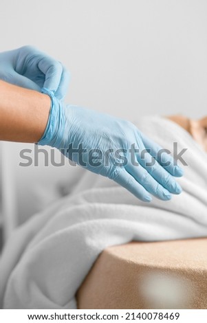 Beautician in blue gloves. Cosmetology room, skin care procedures. Massage.. The scientist wearing blue rubber gloves before experimenting in the laboratory. Gloved Medic