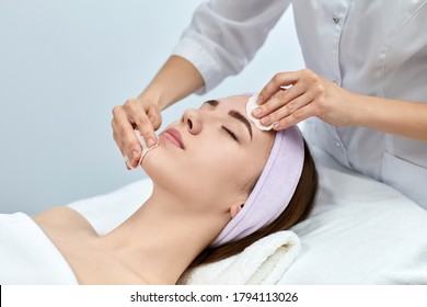 beautician cleanses skin of beautiful woman with a sponge. Perfect cleaning, spa treatment skincare face. - Powered by Shutterstock