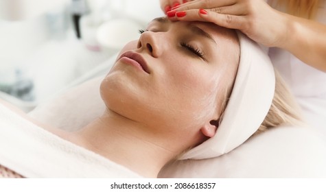 Beautician cosmetologist makes face massage, professional  cosmetic procedure in a beauty clinic salon for client. Skincare and cosmetology spa concept. - Shutterstock ID 2086618357
