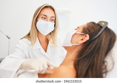 Beautician Or Dermatologist With Face Mask During Skin Treatment In The Cosmetic Studio