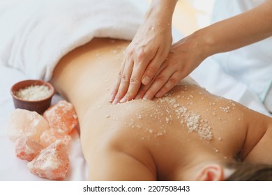 Beautician Exfoliating Back Of Male Client With Sea Salt Scrub