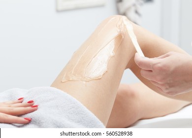 Beautician Giving Epilation Wax Treatment To Woman On Thigh