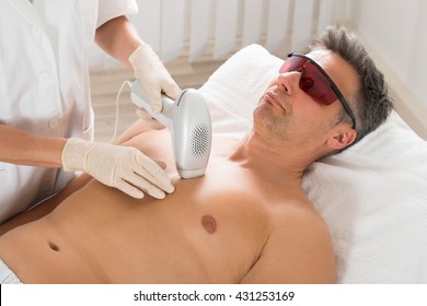 Beautician Giving Laser Epilation Treatment To Mature Man In Clinic
