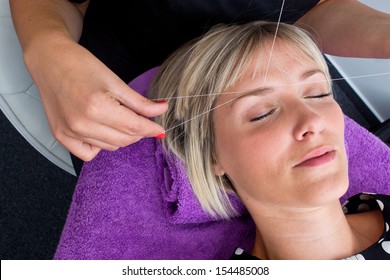 Beautician Makes Threading Hair Removal Procedure To Blond Woman In Salon