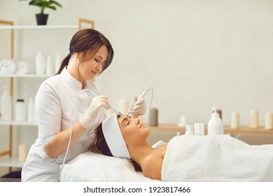 Beautician makes a young beautiful girl a vacuum facial treatment for rejuvenation. Girl is undergoing a course of spa treatments in the office of a beautician. - Shutterstock ID 1923817466