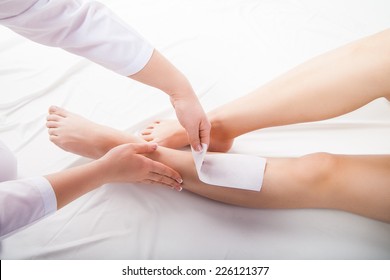 Beautician Waxing  Woman Legs In A Spa Salon