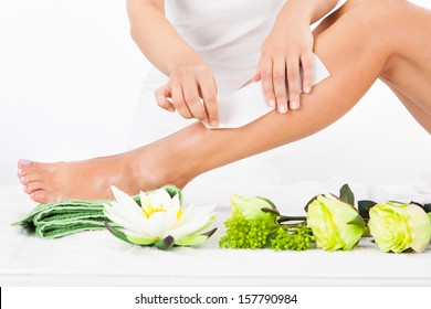 Beautician Waxing A Woman's Leg In Spa