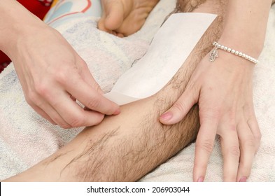 Beautician While Making A Male Waxing With Wax Strips.