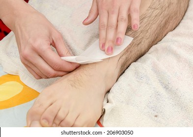 Beautician While Making A Male Waxing With Wax Strips.