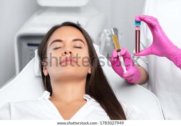 Beautician will do PRP therapy for the face
against wrinkles
and against hair loss of a beautiful woman in
beauty salon.Doctor holds test tubes with venous blood and blood
plasma.Cosmetology
concept.