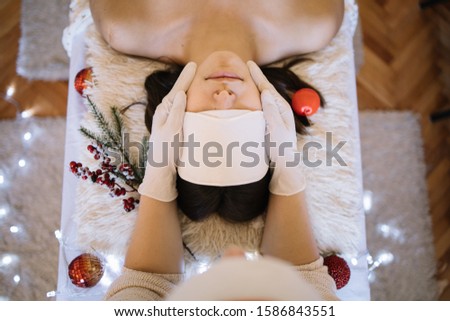 Beauticians hand with latex gloves on girls face