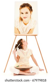 Beautiful 10 year old tween girl sitting beneath easel with self painting over white.