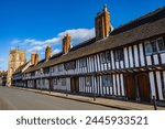 Beautiful 15th Century almshouses in the historic town of Stratford-Upon-Avon, UK.  The tower of the Guild Chapel can be seen in the distance.