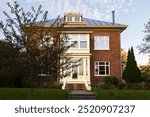 Beautiful 1920s neoclassical brown brick house with metal roof, symmetrical facade and pale beige details, Montcalm sector, Quebec City, Quebec, Canada