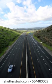 A Beautiful 6 Lane Highway On A Toll Road In Orange County California With Cars And Green Valley Walls On Both Sides