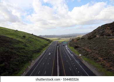 A Beautiful 6 Lane Highway On A Toll Road In Orange County California With Cars And Green Valley Walls On Both Sides