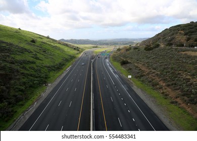 A Beautiful 6 Lane Highway On A Toll Road In Orange County California With Cars And Green Valley Walls On Both Sides