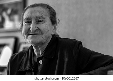 Beautiful 80 Plus Year Old Senior Woman Portrait. Black And White Image Of Elderly Woman Looking At Camera Smiling.