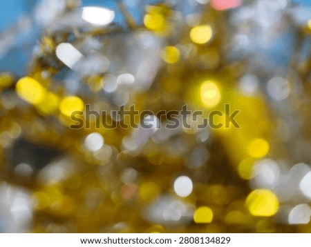 A beautiful abstract background featuring defocused bokeh lights in golden and silver hues, creating a festive and magical atmosphere.