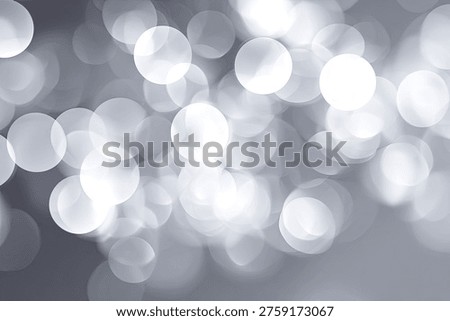 A beautiful abstract background featuring soft-focused silver bokeh lights, creating a shimmering and dreamy effect. Perfect for festive, elegant, or celebratory designs.