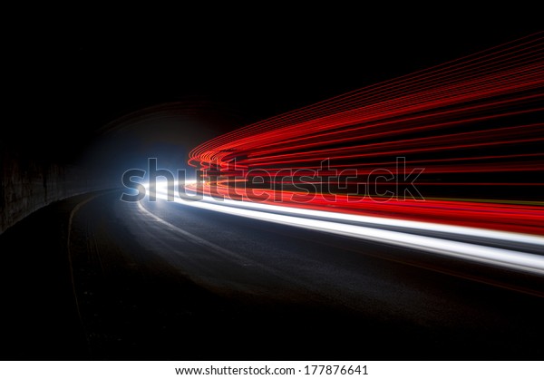 Beautiful abstract lights in a car tunnel in\
white, green,\
purple,red