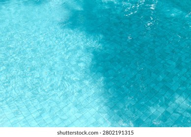 Beautiful abstract pattern created by sunlight and shadows on a clean swimming pool surface. Excellent background for travel advertising, wellness campaigns, hospitality branding, summer promotions and luxury lifestyle projects.