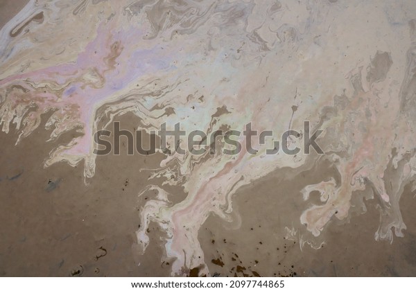 Beautiful abstract stain of motor\
oil, gas or petrol spilled on the asphalt. Marbling\
background