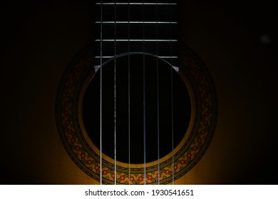 beautiful acoustic wooden guitar close up in the dark