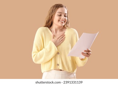 Beautiful actress with film script on beige background