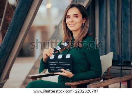 
Beautiful Actress Holding a Film Slate Smiling at the Camera. Professional casting director enjoying her job on set
