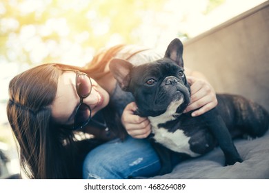Beautiful and adorable French bulldog sitting with her owner girl in cafe bar. Hot summer day. Strong backlight. - Shutterstock ID 468264089
