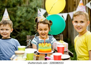 Beautiful Adorable Six Year Old Girl Celebrating Her Birthday With Family Or Friends With Homemade Baked Cake In A Backyard. Birthday Party For Kids.