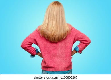 Beautiful Adult Blonde Woman With A Proud, Satisfied And Happy Look, With Both Hands On Hips, As If Confidently Facing A Challenge. Akimbo Arms Pose With. May Have An Angry Expression. Back Pose