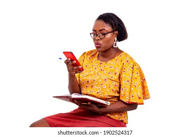 beautiful adult businesswoman wearing optical glasses, holding a notebook and using a mobile phone while smiling.