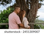 Beautiful adult couple in love talking and looking at their natural surroundings, daydreaming. Happy romantic husband and wife outdoors. Mother