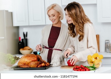 Beautiful Adult Daughter And Senior Mother Cooking Thanksgiving Dinner Together