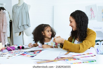 Beautiful Adult Mother Teaching, Bonding Her Mixed Race African Little Cute Daughter Girl Using Sewing Machine For Making Dress, Clothes At Home Or Tailor Shop, Smiling With Happiness Together